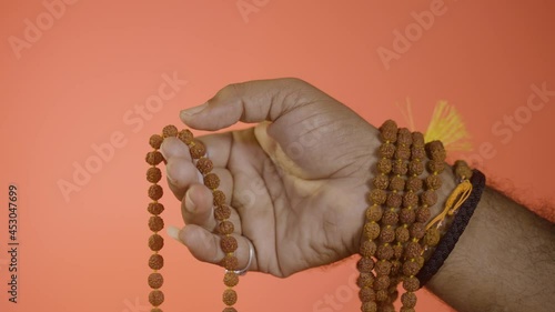 Close up hands of monk or Indian priest meditating or chanting using rudrakshi japa mala. photo