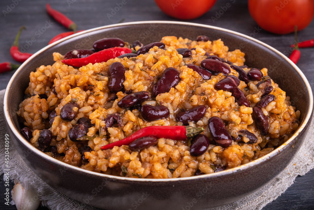 Spanish tomato rice with beans and hot peppers in a bowl, close-up