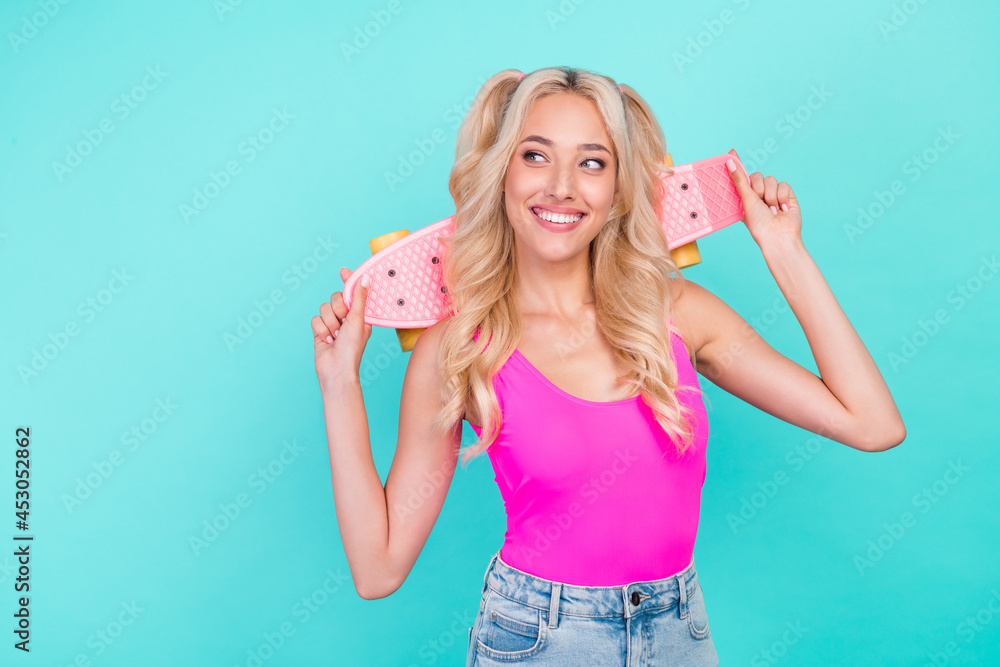 Fototapeta premium Portrait of attractive cheerful carefree wavy-haired girl holding skate good mood rest isolated over vivid teal turquoise color background