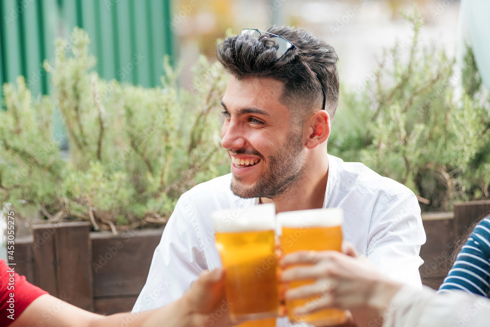 Trendy smiling man partying with his friends at an outdoor pub Trendy smiling man partying with his friends at an outdoor pub