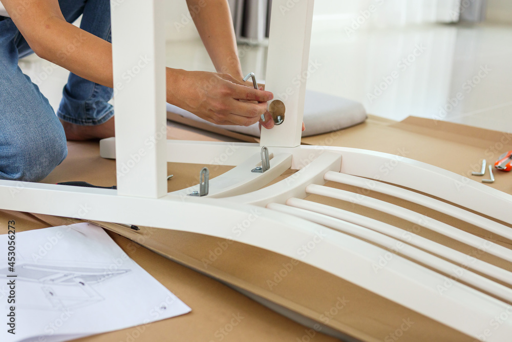 Man assembling white chair furniture at home Man assembling white chair furniture at home