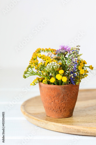 Bouquet of wild flowers in ceramic vase.