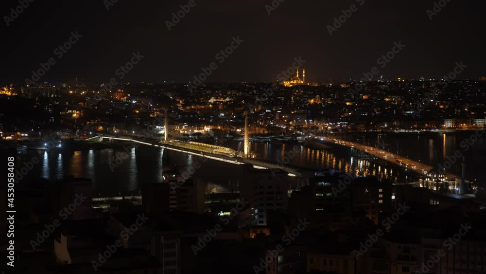 Night city illumination on bridge over river in urban landscape. Beautiful landscape night city, traffic cars and Galata bridge in backlight over dark Golden horn Night city illumination on bridge over river in urban landscape. Beautiful landscape night city, traffic cars and Galata bridge in backlight over dark Golden horn