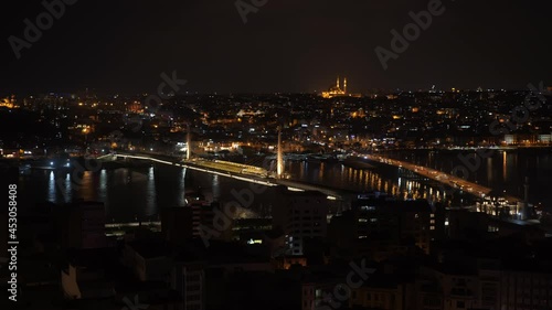 Night city illumination on bridge over river in urban landscape. Beautiful landscape night city, traffic cars and Galata bridge in backlight over dark Golden horn