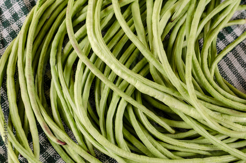 Raw green bean pods close-up. Long raw bean pods of asparagus in