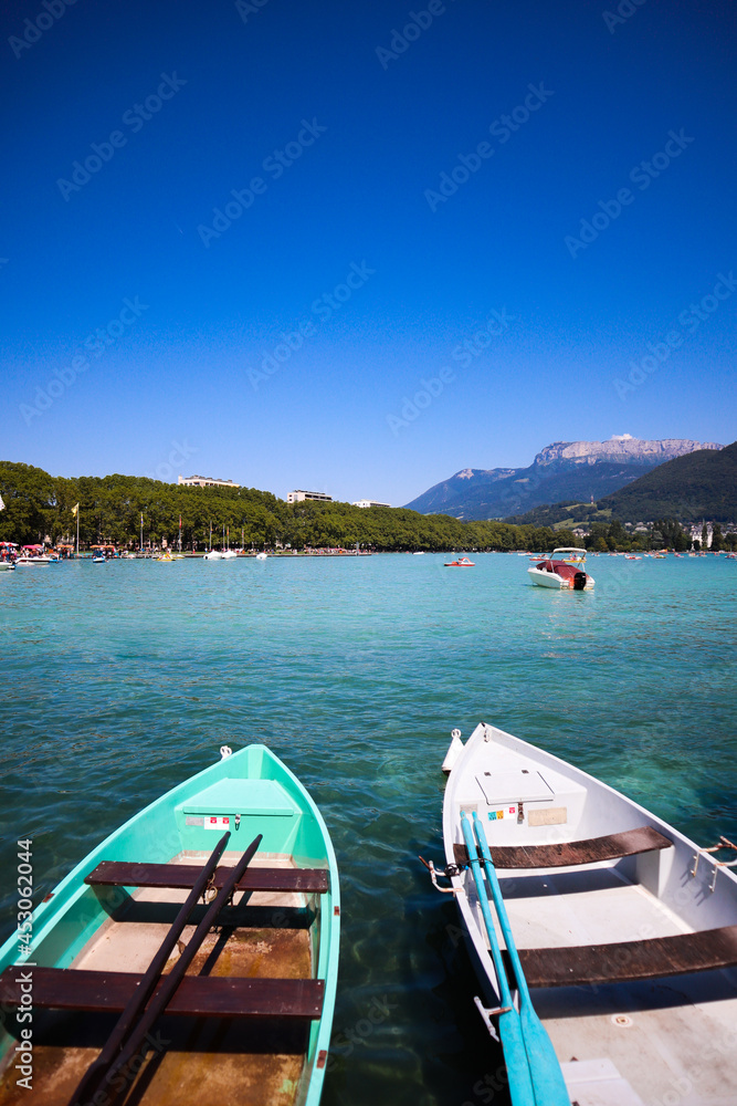 Boats at Annecy lake in France with beautiful mountains in the background
