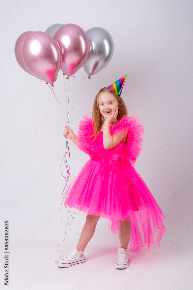 a little girl celebrates her birthday on a white background