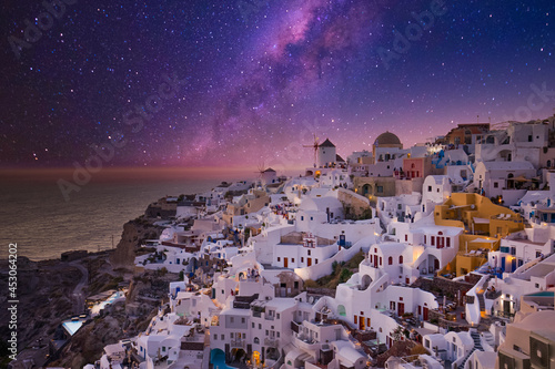 Sunset night view of traditional Greek village Oia on Santorini island in Greece. Iconic travel destination landscape in Greece, famous scenic over traditional white architecture. Luxury vacation