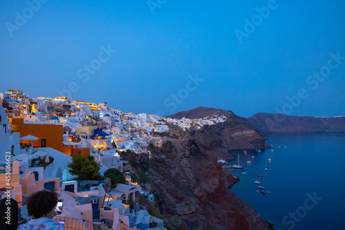 Night time blue hour view of the cliff side white cave accommodation of Oia on the Greek island of Santorini. 