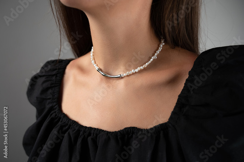 Woman wearing pearl necklace, cropped view