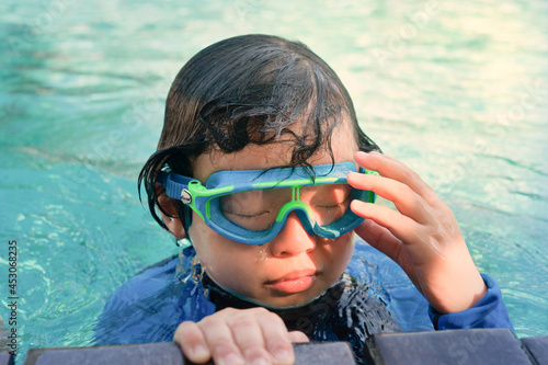 kid in goggles in swimming pool