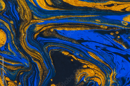 Abstract space blue gold black background. Acrylic painting fluid art. Golden waves of the ocean. Conceptual art drawing. Fashionable background for posters, postcards, invitations. Contemporary art