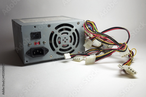 computer ATX power supply unit rear side with fan and line power socket. colorful power cords for conneting to drives photo