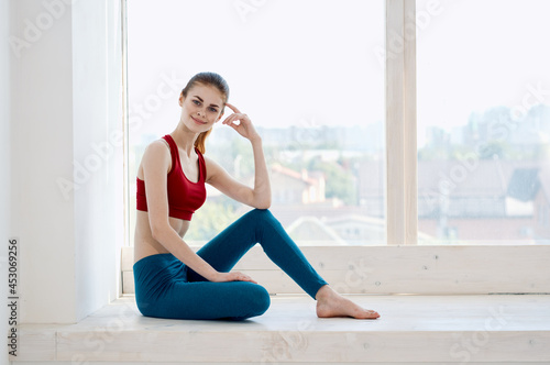 woman doing yoga near window relaxation meditation lifestyle