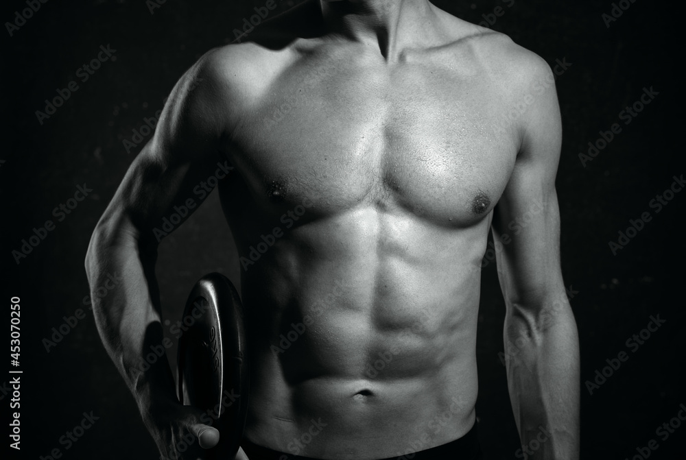 Fototapeta premium male athletic physique cropped view muscle dark background