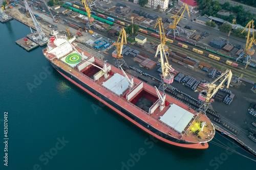 Container ship in export and import business and logistics. Shipping cargo to harbor by crane. Water transport International. Aerial view from drone