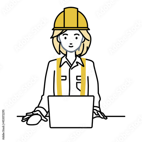 デスクで座ってPCを使っている工事現場の女性