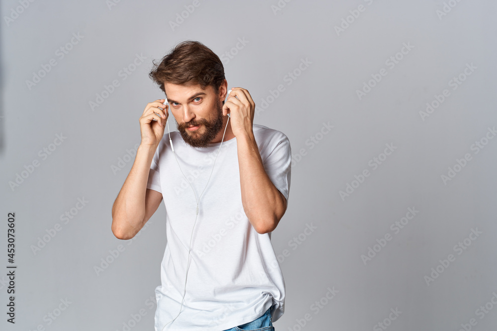 Cheerful bearded man on a white t-shirt emotions holds his hand near his face Cheerful bearded man on a white t-shirt emotions holds his hand near his face