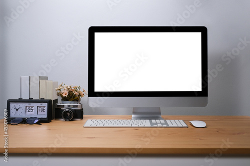 Blank screen desktop of computer on wooden table, comfortable workspace.
