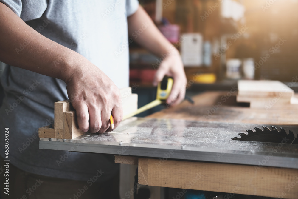 do-it-yourself concept Craftsmen use a tape measure to assemble wooden pieces to make wooden tables for customers. do-it-yourself concept Craftsmen use a tape measure to assemble wooden pieces to make wooden tables for customers.