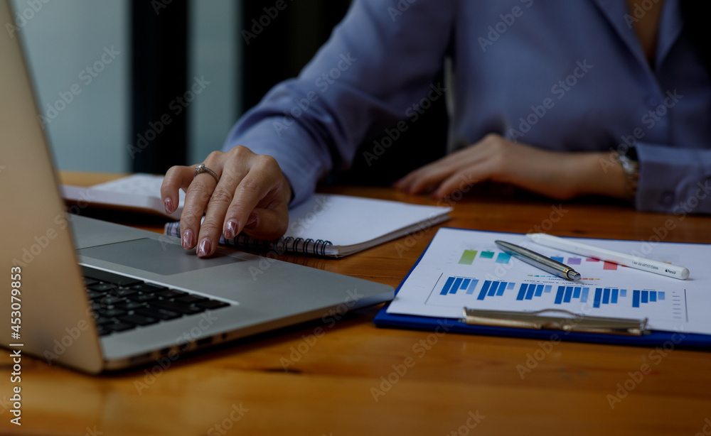 Close up of woman working on project for analyzing company financial report balance statement with documents graphics at modern office. business,economy, market,money and tax concept . Close up of woman working on project for analyzing company financial report balance statement with documents graphics at modern office. business,economy, market,money and tax concept .