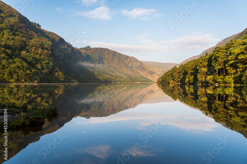 Tranquil summer morning at the Glendalough Upper Lake in Wicklow Mountains, Ireland, with lovely mountain reflections in the still lake waters. photo