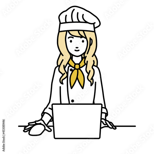 デスクで座ってPCを使っている調理師の女性
