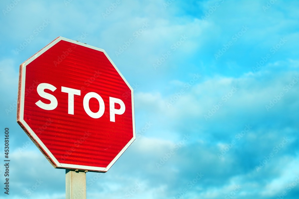 Stop sign with cloudy sky background