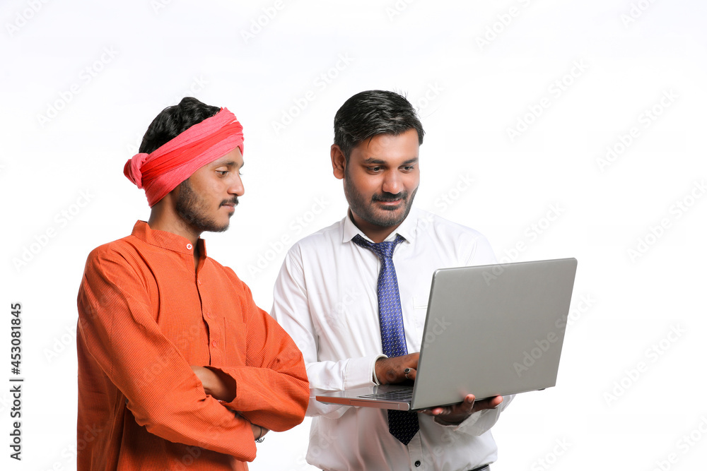 Indian bank officer or corporate government employee showing some information to farmer in laptop.