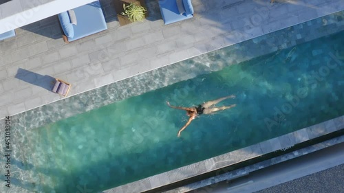 top areal shot of woman swimming at the villa pool