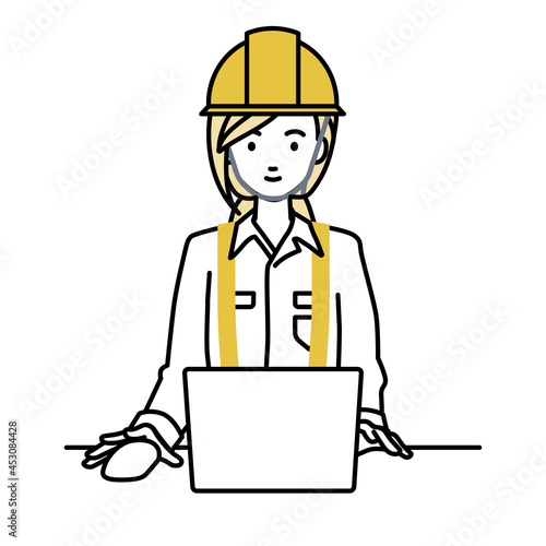 デスクで座ってPCを使っている工事現場の女性