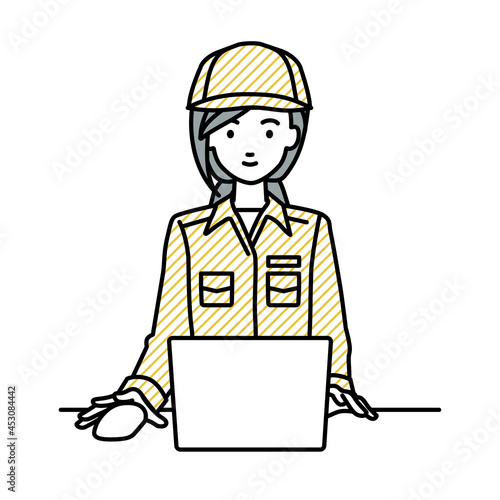 デスクで座ってPCを使っている作業員の女性