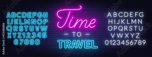Time to travel neon lettering on brick wall background.
