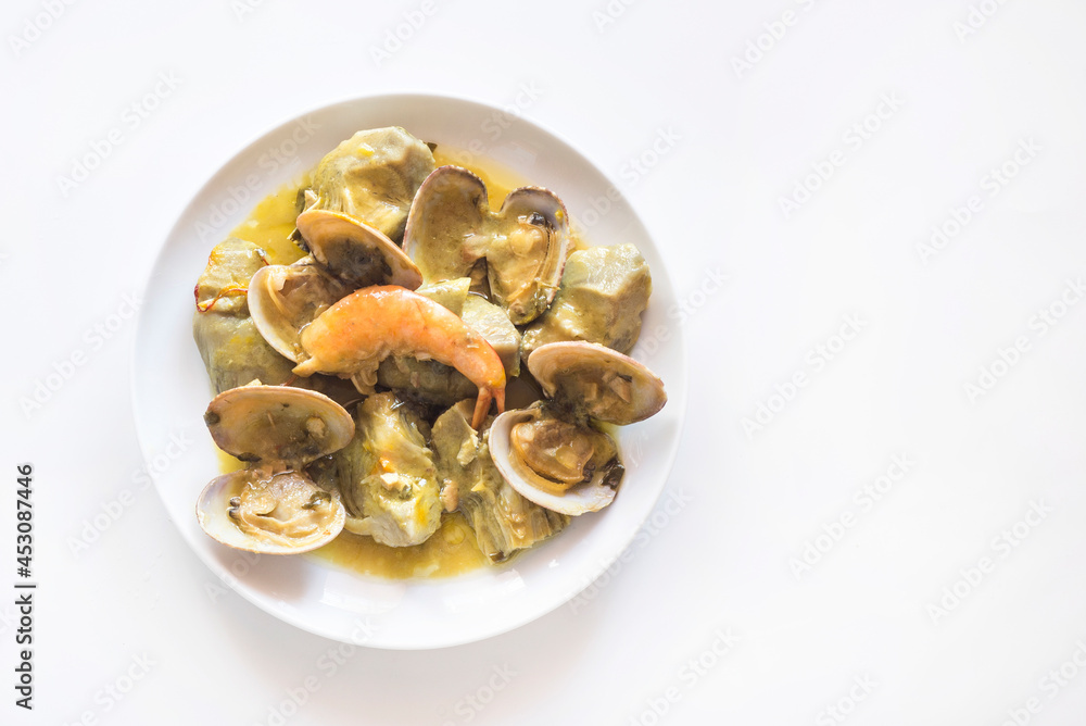 Artichokes with clams and prawns, typical traditional Spanish food for Christmas and New Year