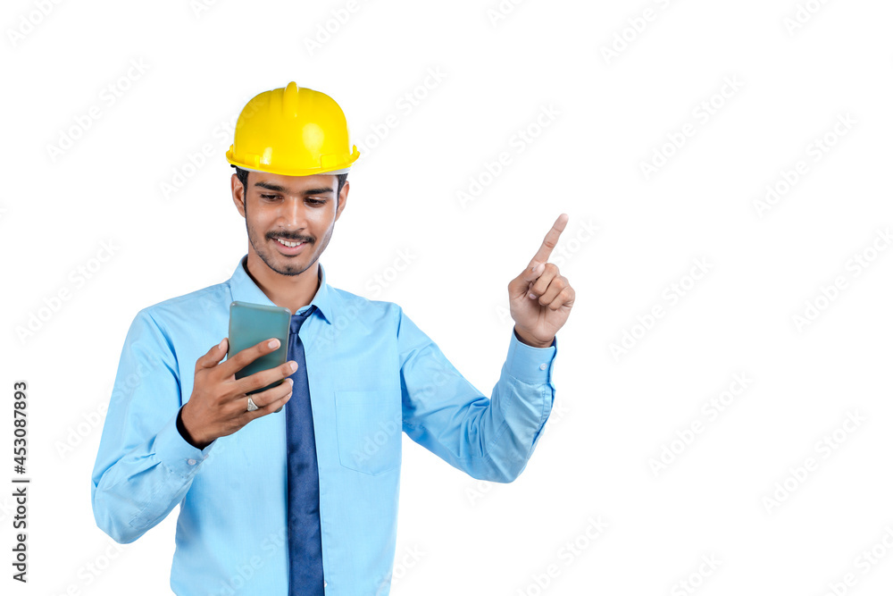 Young indian engineer or construction site worker using smartphone. Young indian engineer or construction site worker using smartphone.