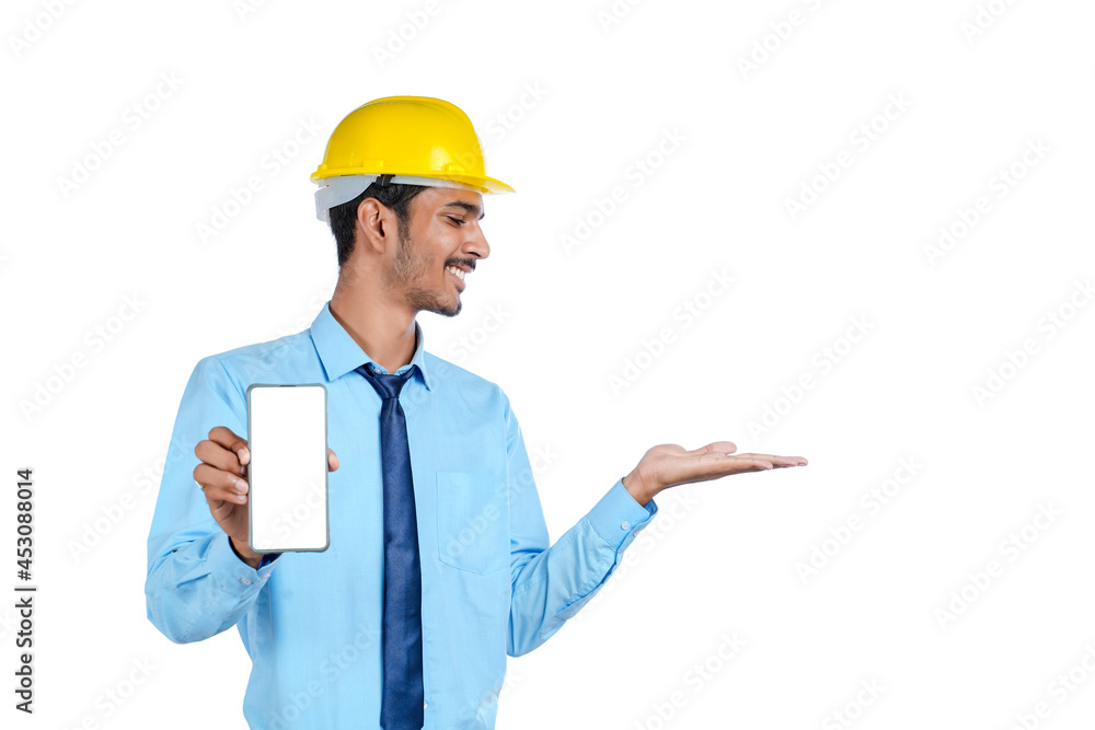 Young indian engineer or Construction Worker Showing Smartphone Screen.