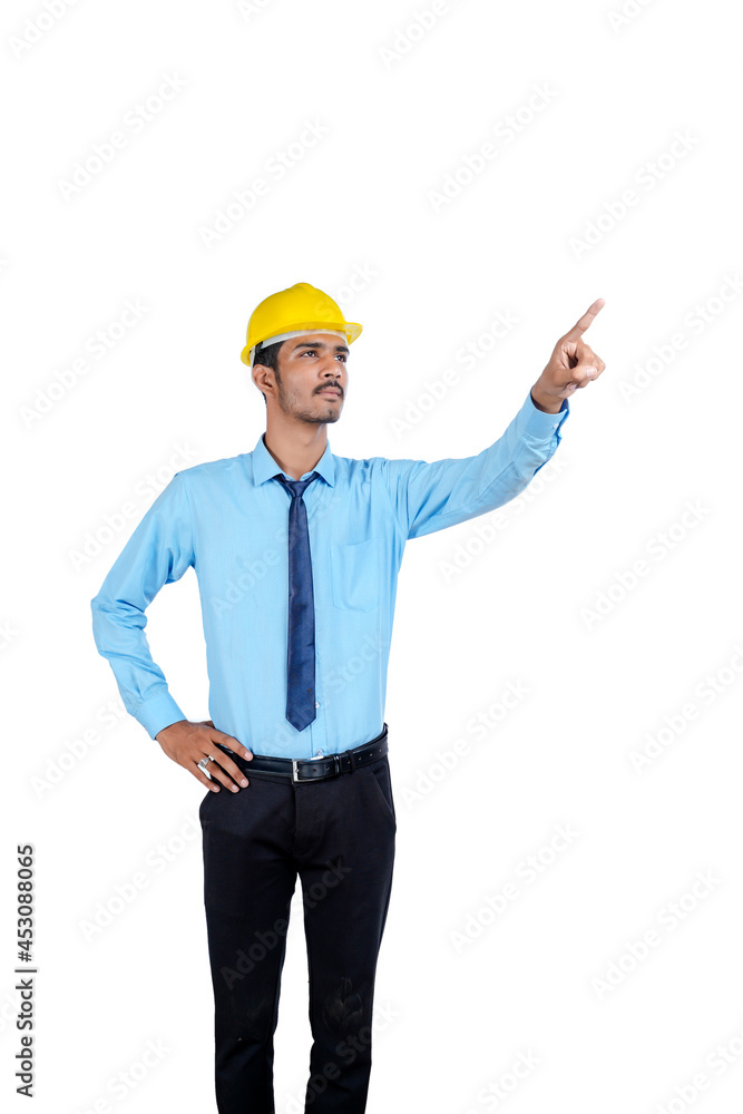 Young Indian male engineer wearing yellow color hard hat on white background. Young Indian male engineer wearing yellow color hard hat on white background.