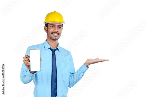 Young indian engineer or Construction Worker Showing Smartphone Screen.