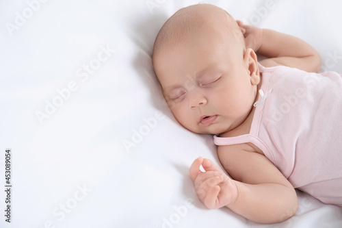 Cute little baby sleeping on bed, above view. Space for text