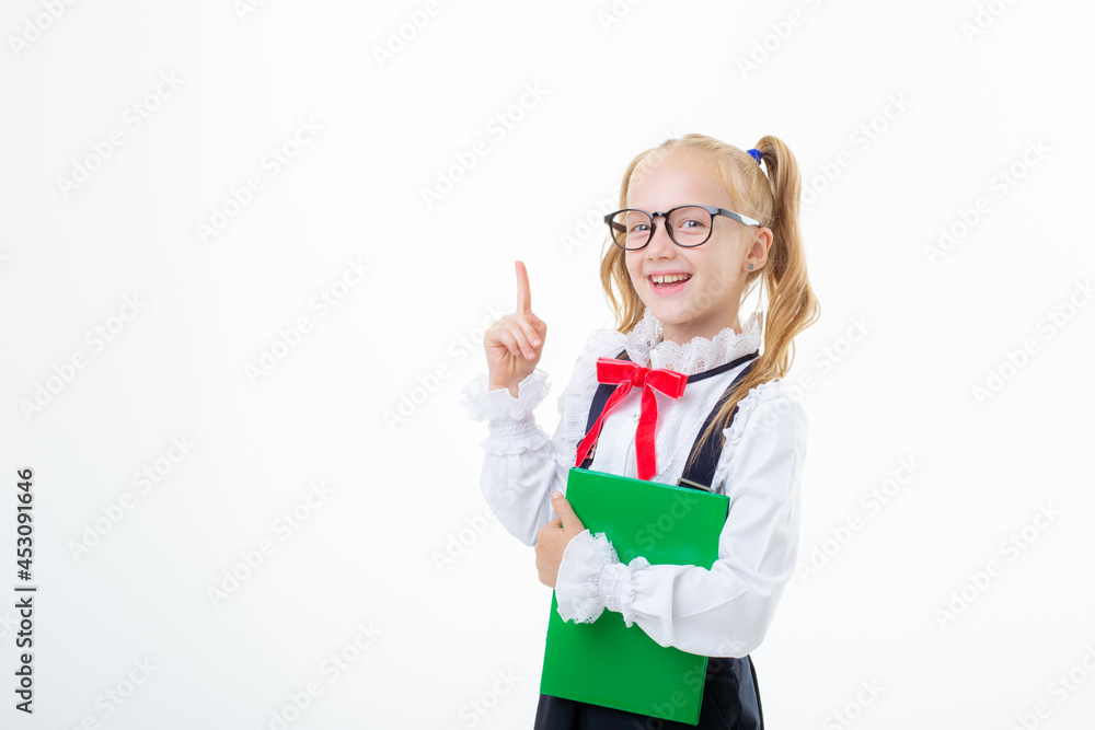 a little schoolgirl girl in a school uniform holds a book isolated on a white background a little schoolgirl girl in a school uniform holds a book isolated on a white background