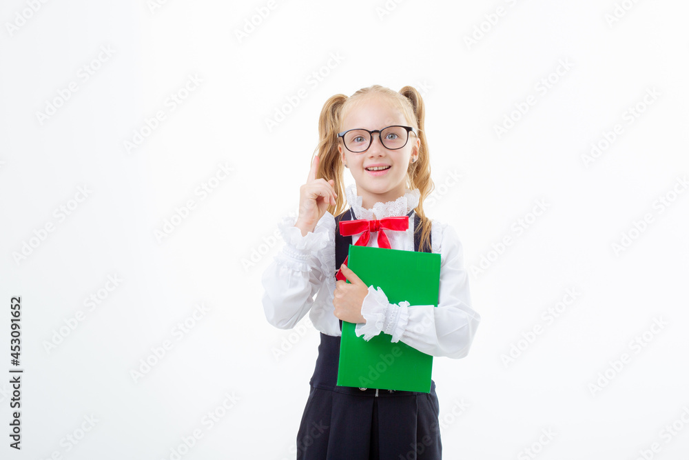 a little schoolgirl girl in a school uniform holds a book isolated on a white background a little schoolgirl girl in a school uniform holds a book isolated on a white background