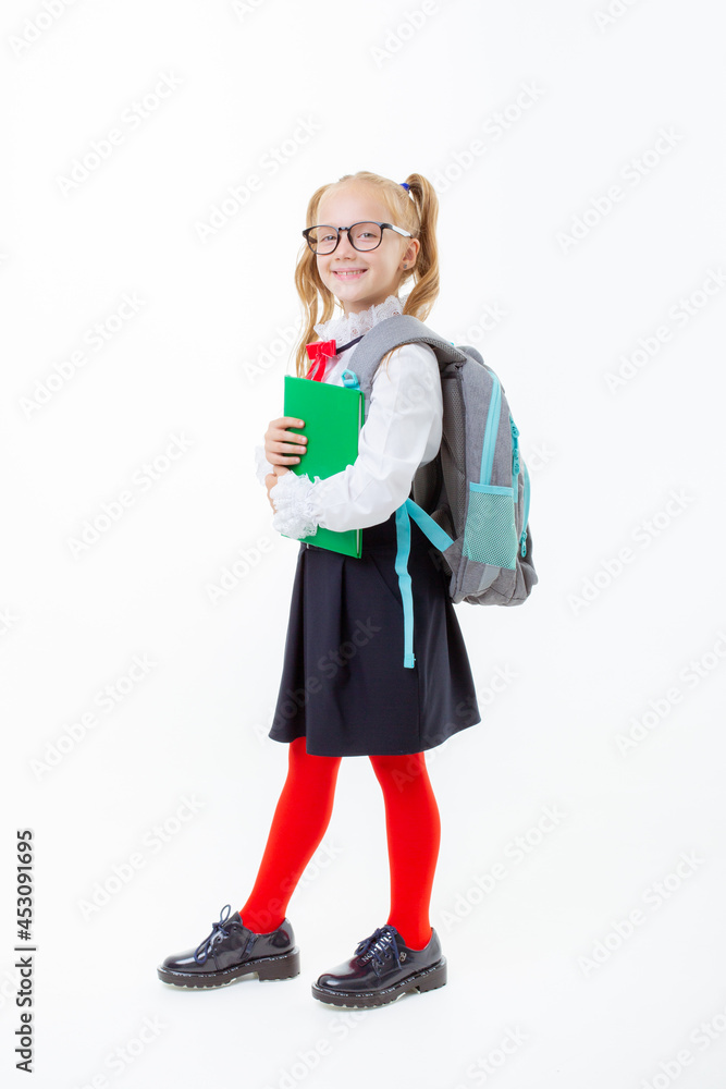 a little schoolgirl girl in a school uniform holds a book isolated on a white background a little schoolgirl girl in a school uniform holds a book isolated on a white background