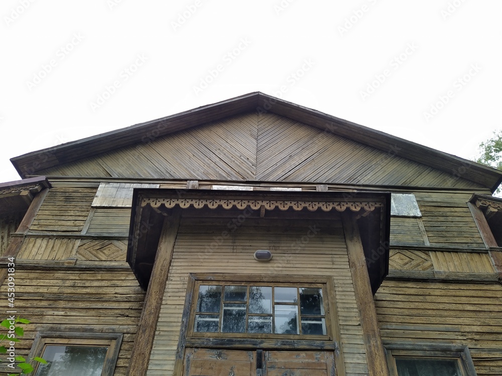 old and abandoned wooden building against the gray sky. bottom up view photo.