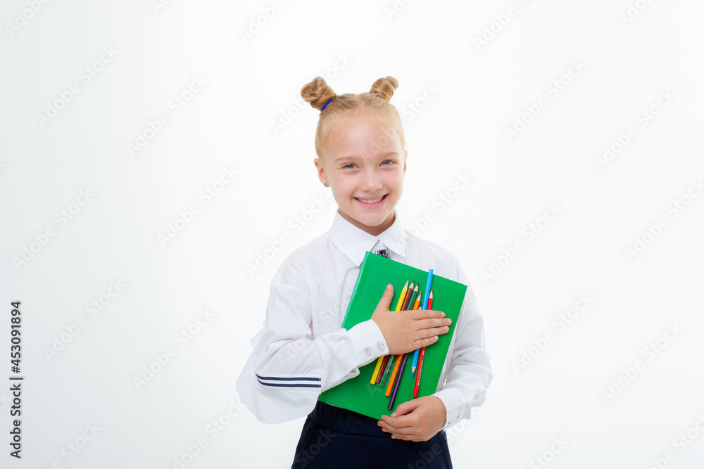 a little schoolgirl girl in a school uniform holds a book isolated on a white background a little schoolgirl girl in a school uniform holds a book isolated on a white background