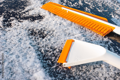 Modern rubber brush and scraper for cleaning snow from a car