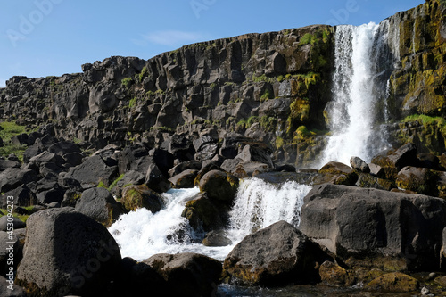 A large waterfall over a rocky cliff -   xar  foss in Thingvellir National Park.