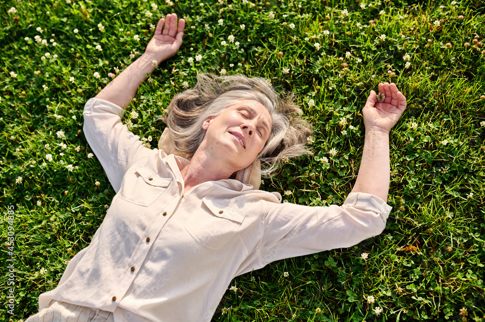 Retired woman relaxing on green lawn Retired woman relaxing on green lawn