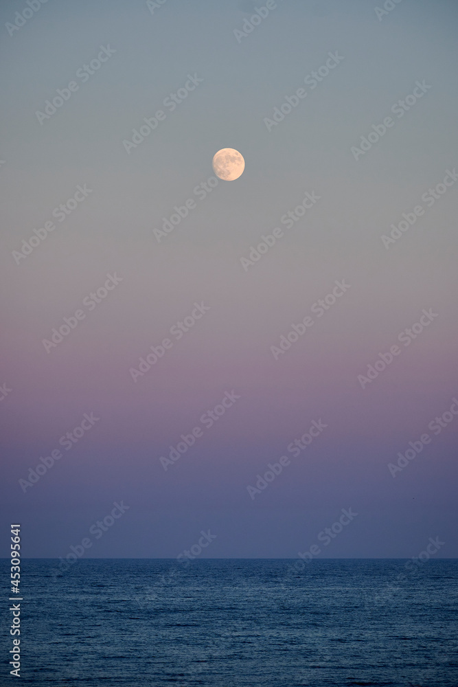 Full moon over the sea at sunset
