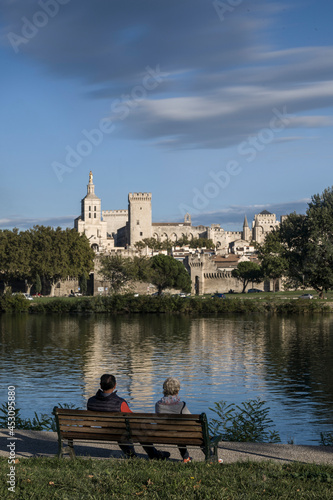 Couple Sit on a Bench And Look at the Palais des Papes in Avignon