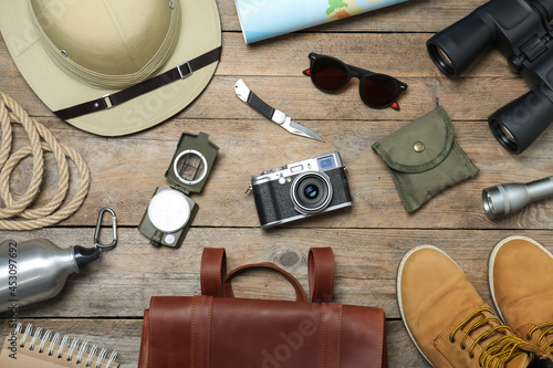 Flat lay composition with different safari accessories on wooden background